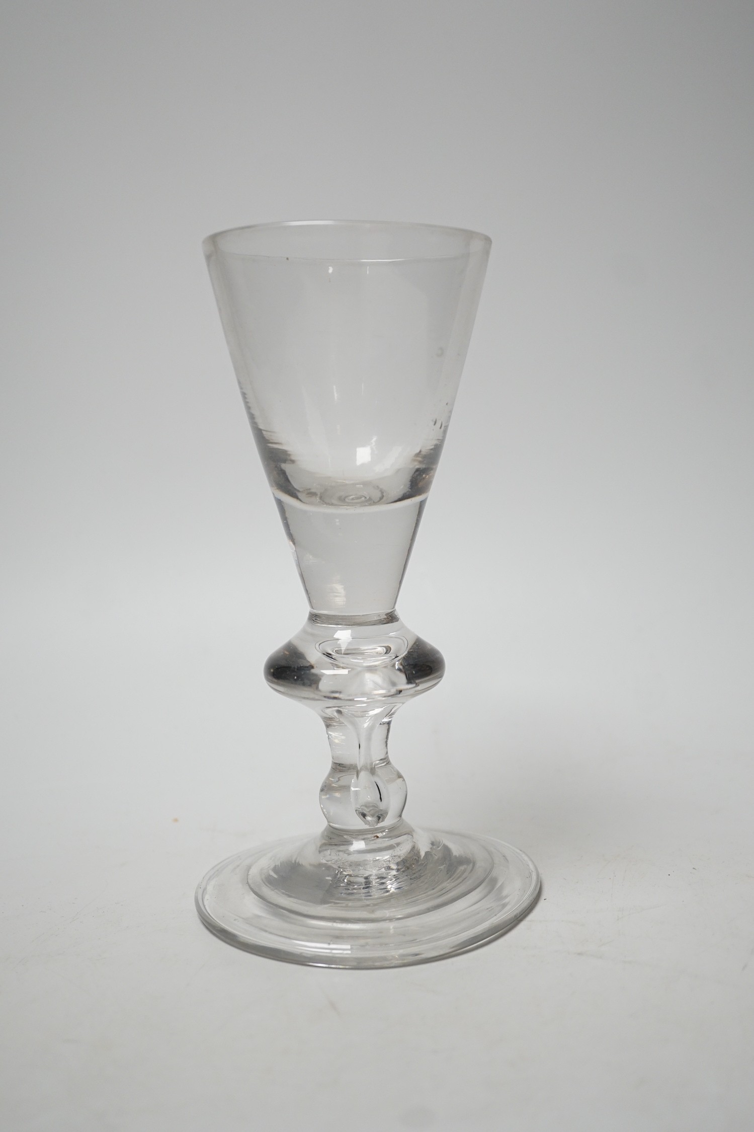 A George I heavy baluster wine glass, round funnel bowl above angular knop with air-tear, circa 1715-20, 18cm